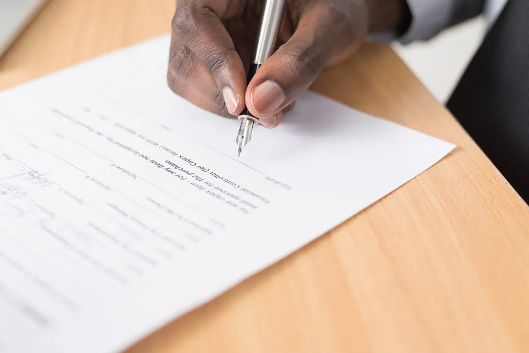 Un contrat de bail de location posé sur un bureau en bois avec un stylo, illustrant les mentions légales des charges.