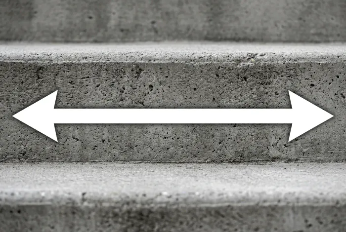 Gros plan sur une marche d'escalier béton avec flèche illustrant l'agrandissement du giron